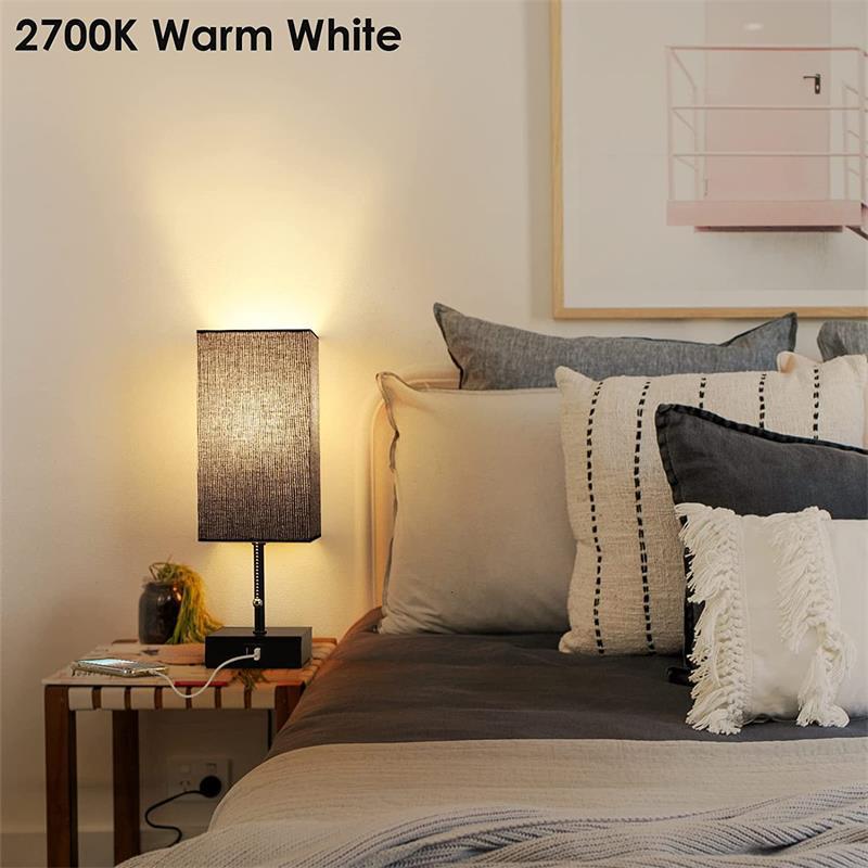 Bedroom with a lamp on a nightstand emitting 2700K warm white light.