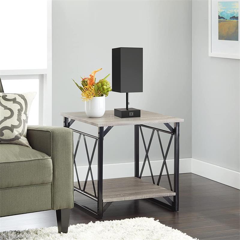 Side table with black lamp and plant in a living room setting