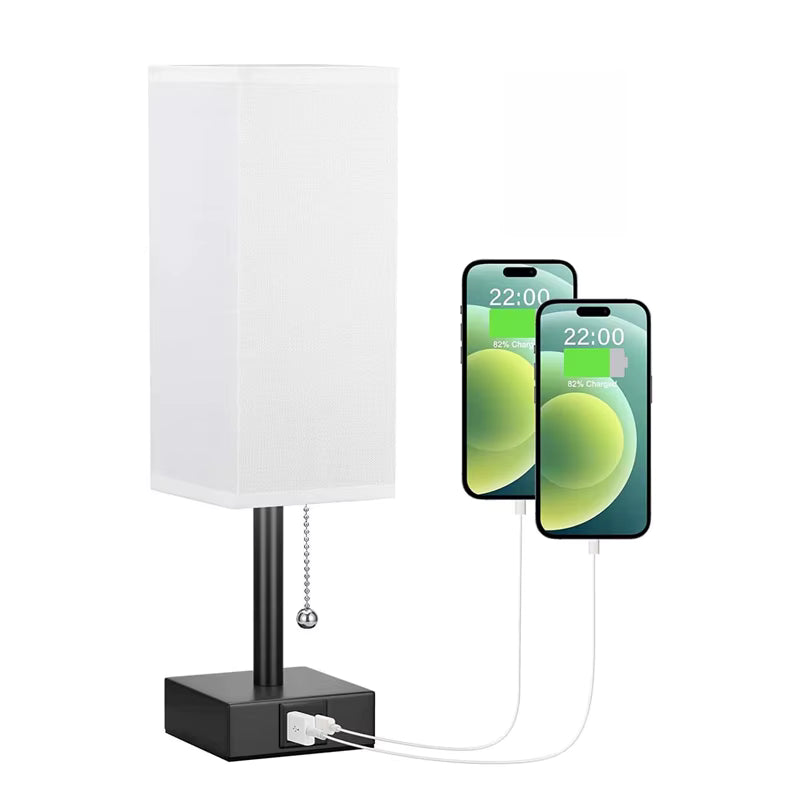 Table lamp with a white shade and black base, connected to two smartphones showing a green screen.