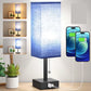 Blue LED table lamp with USB charging port on a wooden surface, surrounded by smartphone screens displaying time.