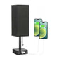 Black lamp with USB charging port and two smartphones displaying battery icons.