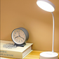 Desk lamp and clock on a book with a yellow background
